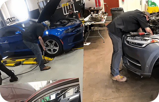 Three mechanics work on cars in a garage: one uses a jack on a blue car, another leans into a gray car's engine, and a third works on a red car.